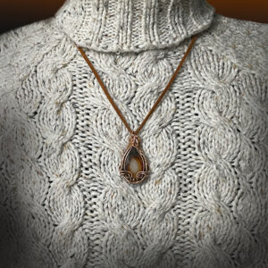Fortification Agate pendant in tones of brown with copper frame.