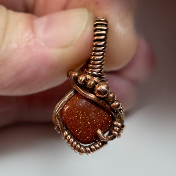 red goldstone and copper pendant